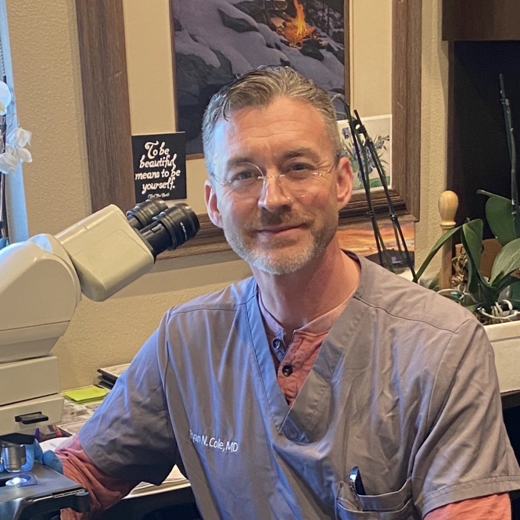 A doctor with a microscope smiling at the camera